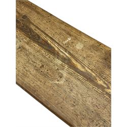 Late Victorian ecclesiastical pitch pine side table, rectangular bow-front top, on shaped end supports pierced with quatrefoils, united by pegged stretcher 