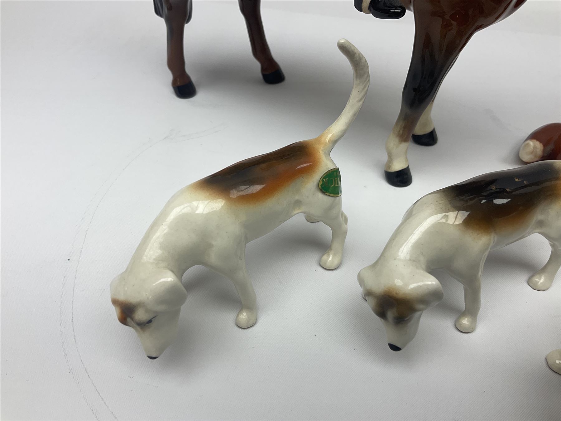 Beswick hunting group, comprising huntswoman on dappled grey horse no 1730, huntsman on bay horse no 1501, two fox figures no 1440 and 1748, and four fox hounds, all with printed marks beneath (8)