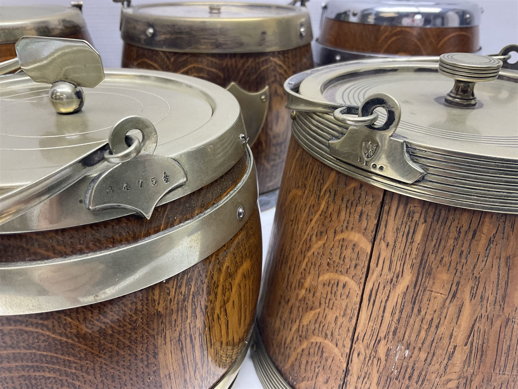 Five early 20th century biscuit barrels with silver-plated mounts