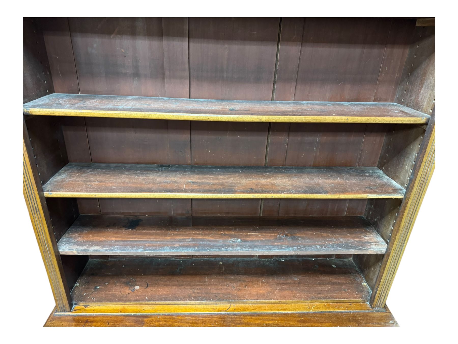 Early 19th century mahogany bookcase on cupboard, projecting cornice over four adjustable shelves, the cupboard enclosed by two sliding panelled doors, on moulded plinth base 