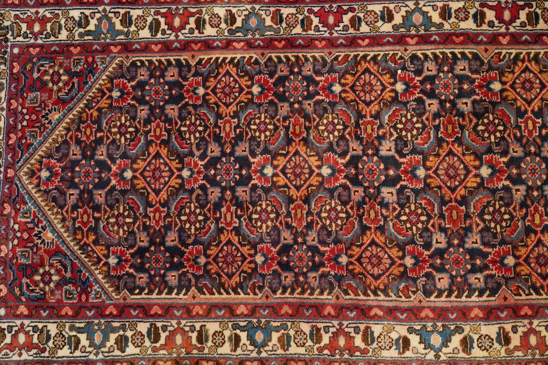 North-west Persian Malayer runner rug, the indigo ground decorated with ivory medallions and an all-over Herati pattern, red floral spandrels, enclosed by an ivory trailing floral border and crimson patterned guard stripes