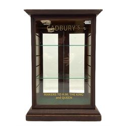 Late 19th century counter top shop display cabinet, glazed front with later Cadbury’s signage, two glazed doors to rear, glass adjustable shelves
