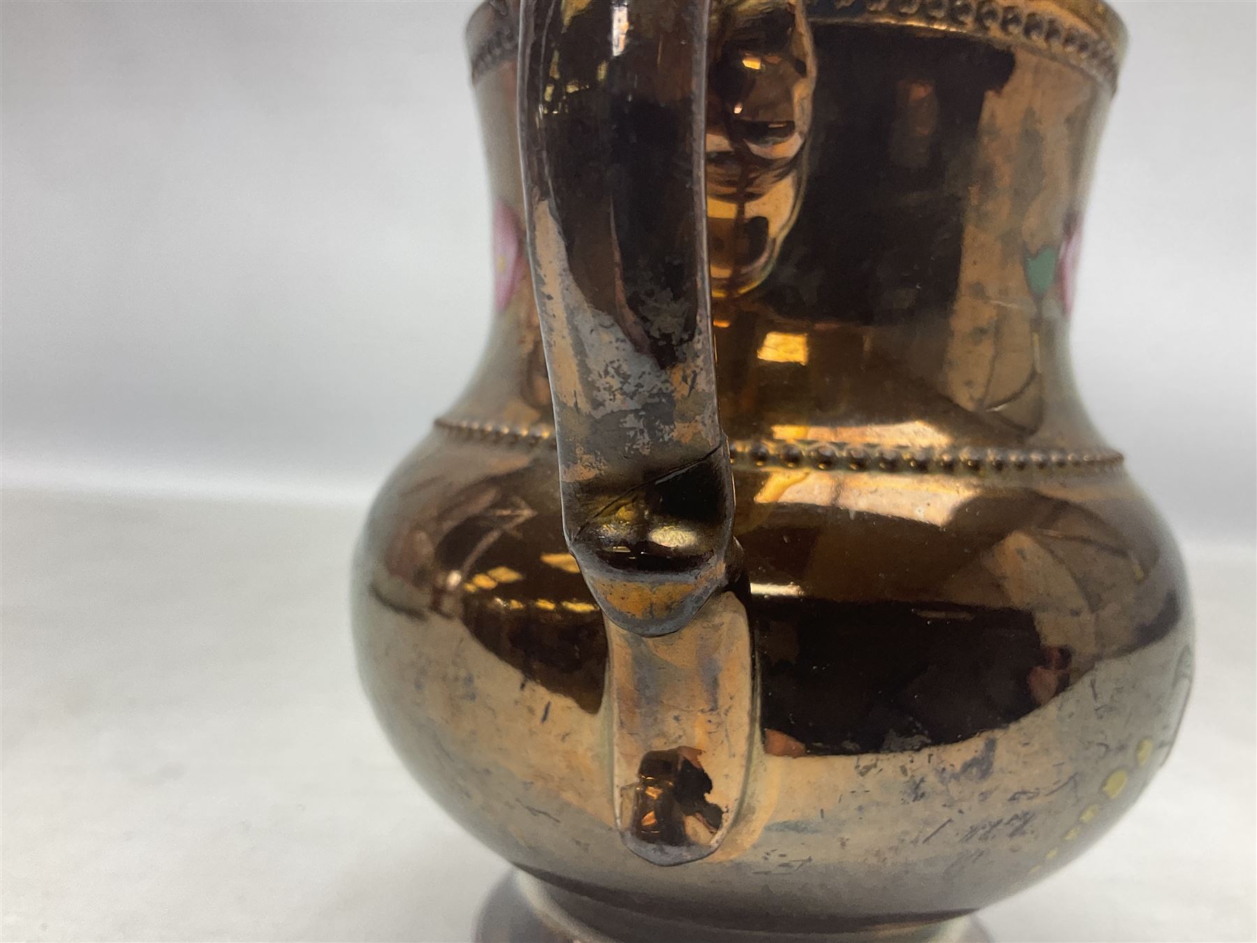 Early 20th century Sunderland lustre jug, decorated with transfer Masonic scene and poem 'The World is in Pain/Our Secrets to Gain/But Still Let Them Wonder and Gaze/The Never Can Divine/The World Nor The Sign/Of a Free and Accepted Mason', the reverse decorated with Sunderland River Wear cast iron bridge scene below text (a/f), together with a copper lustre jug, and pink lustre bowl, jug H20cm