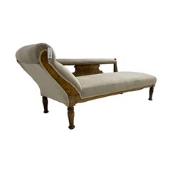 Edwardian carved stained beech chaise longue, the back support and scrolled end carved with foliate decoration,upholstered in pale lilac fabric with sprung seat, on turned supports