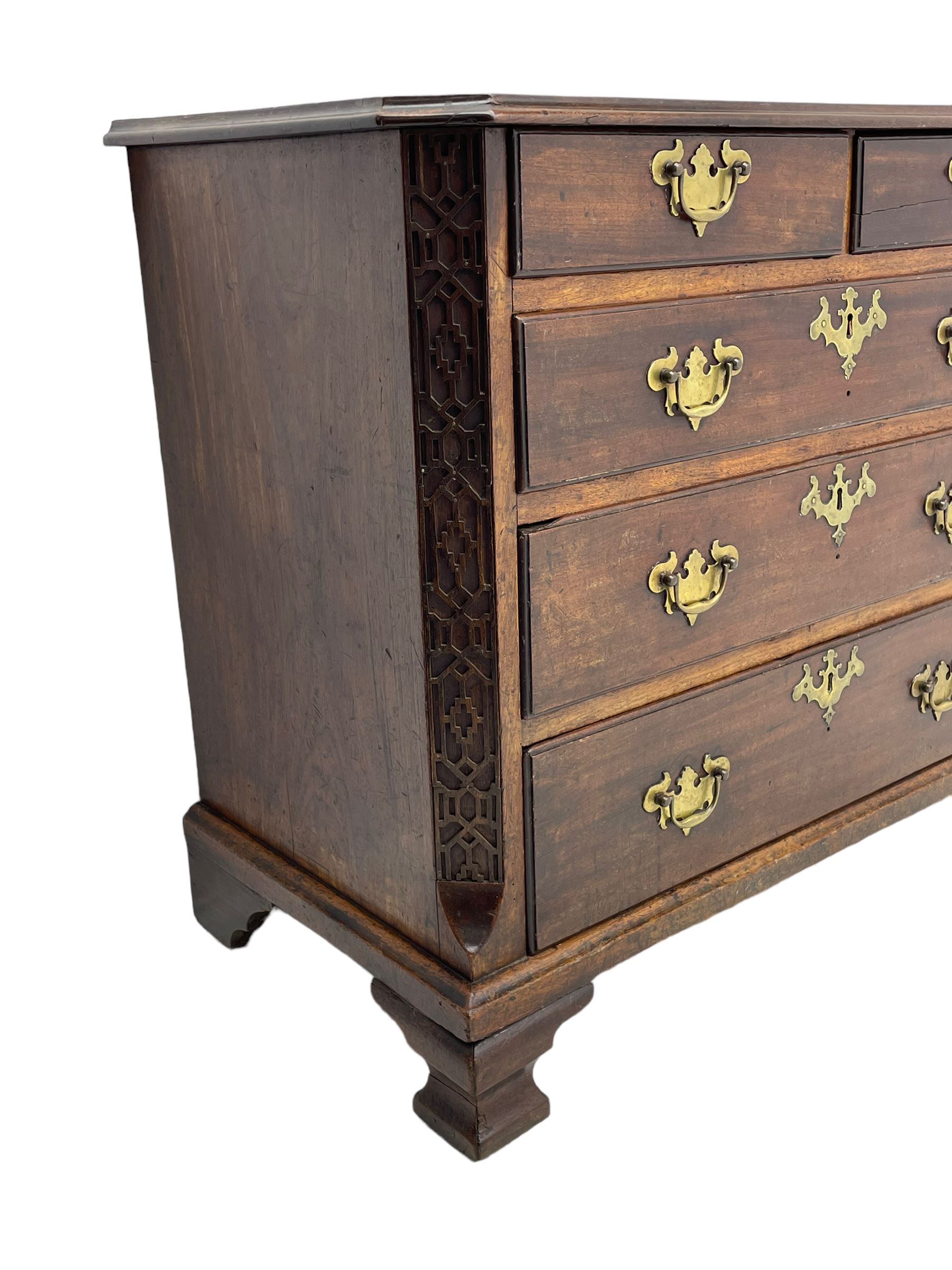 George III Chippendale design mahogany chest, moulded rectangular top with canted corners, wide canted uprights with blind fretwork decoration, two short and three long with moulded fronts, shaped brass handle plates, on ogee bracket feet 