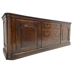 George III oak dresser base, rectangular top with rounded corners over moulded frieze rail, canted corners with turned quarter columns, fitted with three drawers with moulded edges flanked by two cupboards, enclosed by ogee arched fielded panelled doors, panelled sides, moulded plinth base