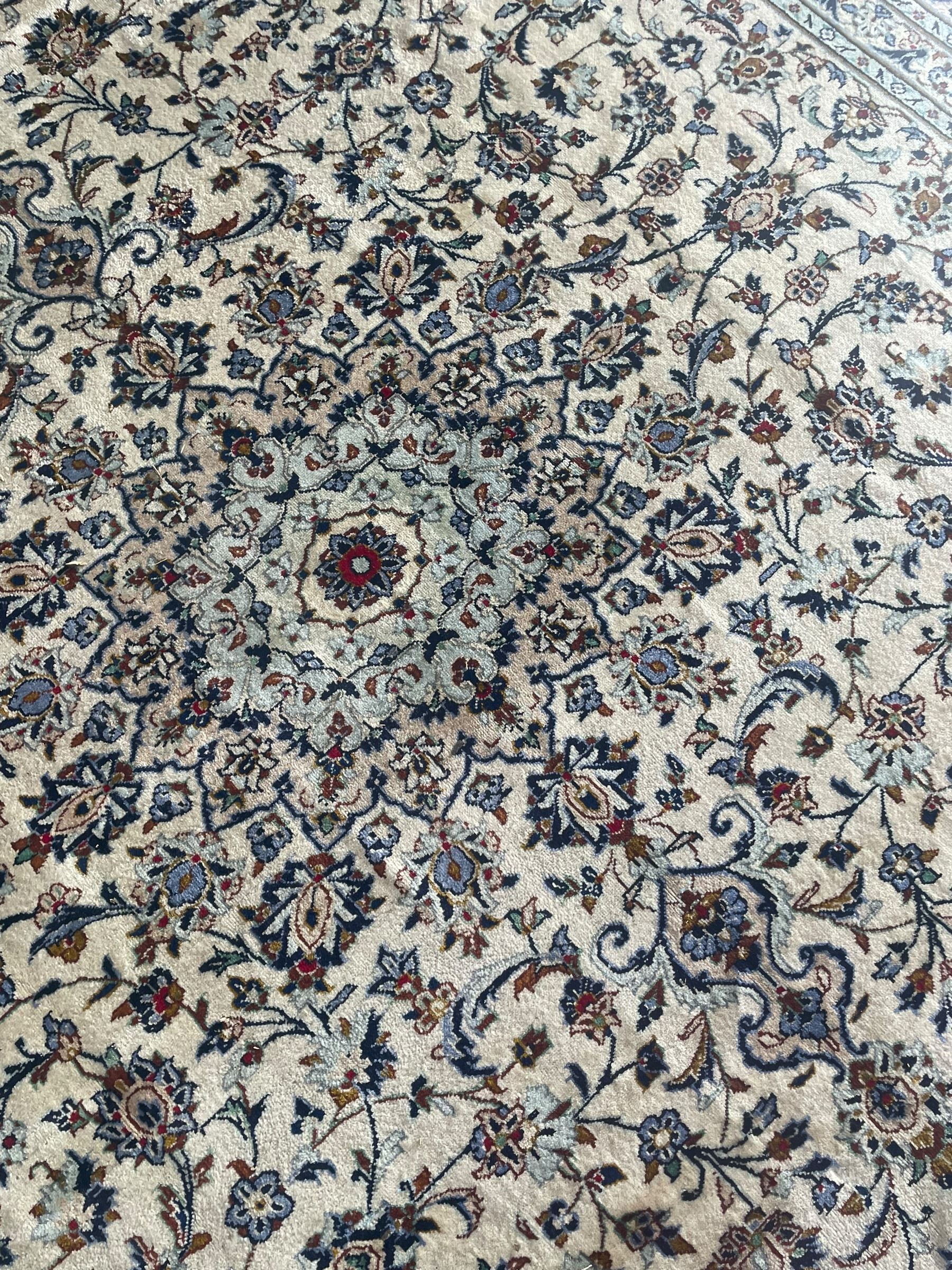 Persian Kashan ivory ground carpet, the field decorated with interlacing foliate branches and stylised plant motifs, scrolling border decorated with repeating palmettes, within floral pattern guard bands