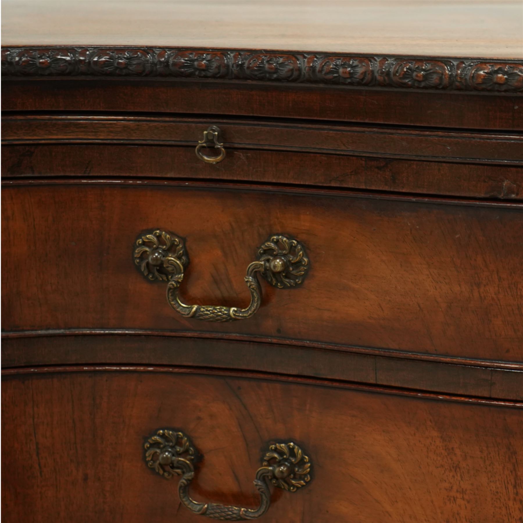 Georgian design mahogany serpentine chest, with rectangular top with floral rosette carved edge, cluster reeded columns with brush slide above four graduated drawers on ogee bracket feet 