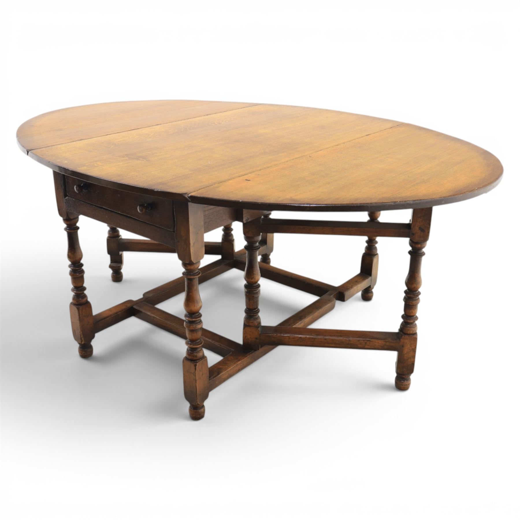 Titchmarsh & Goodwin - 18th century design oak oval drop-leaf dining table with leather dining chairs, the table with drop leaves forming an oval top extending to 180cm, with drawer to either side, raised on turned supports with gateleg, the chairs comprising two carvers in tan leather and two side chairs in green and tan leather backs, brass studded trim with turned uprights and stretchers