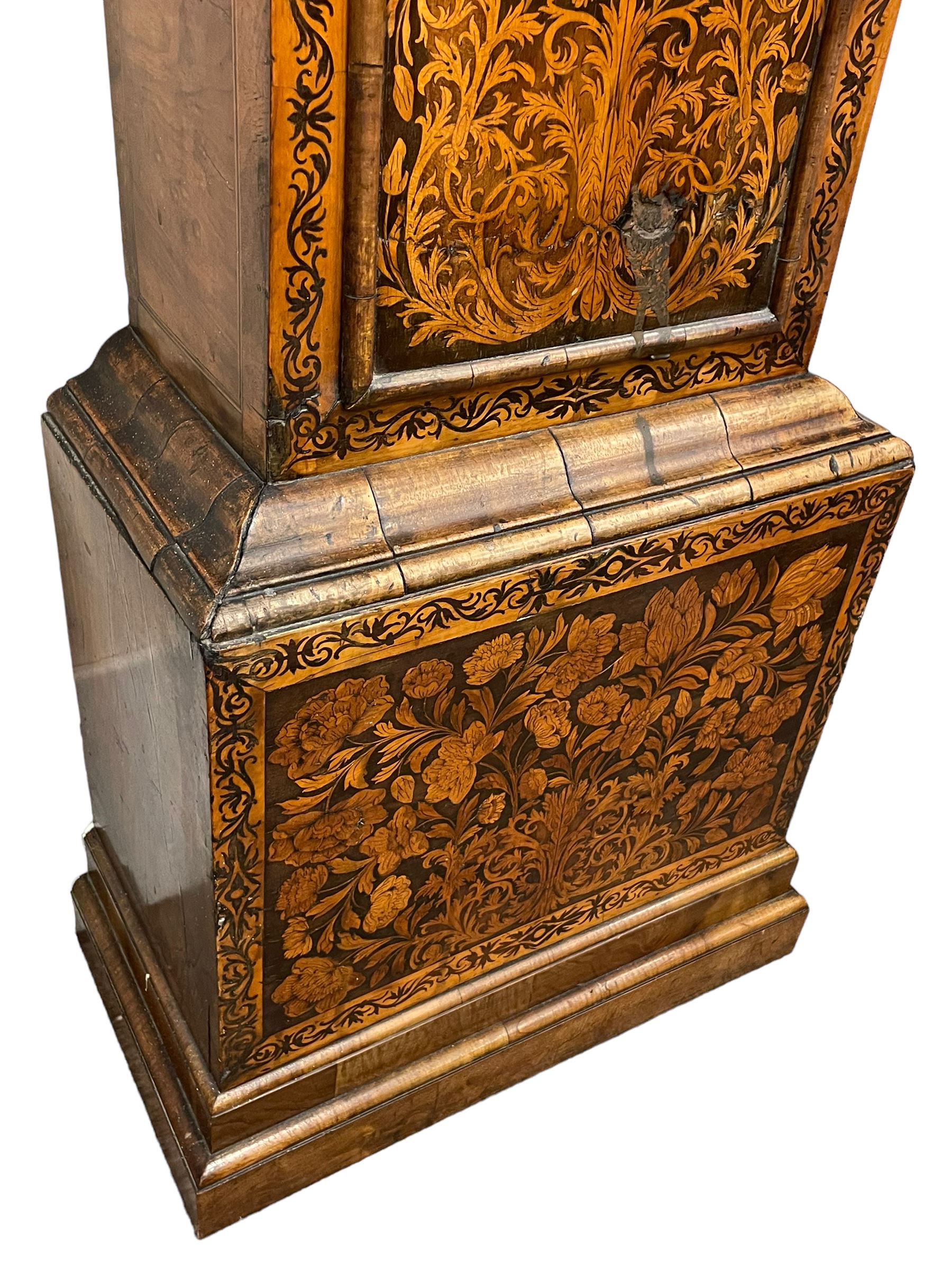 William & Mary floral marquetry 8-day longcase clock c 1700, later mid-18th century four pillar rack striking movement with a square brass dial and subsidiary seconds dial, ringed winding holes and calendar aperture to the matted dial centre, with London cherub head cast spandrels and (later) fretted steel hands, silvered Roman numeral chapter ring with stylised fleur di Lis half hour makers, narrow Arabic five-minutes, minute track and inner quarter hour track, signed Thomas Horlock, Hammersmith, 
case with box upstand to the domed floral marquetry decorated caddy with three brass flame finials, above a moulded cornice and fretwork frieze,  inlaid hood door with attached barley twist pillars to the front above an inlaid convex moulding, full length D moulded trunk door with a circular lenticle inlaid with floral and foliage panels inhabited with birds, on a conforming marquetry plinth with applied double skirting. Thomas Horlock is recorded as a Whitesmith & Clockmaker of Hammersmith, Middlesex.
A copy of Thomas Horlock's will dated the 15th June 1757 is held at The National  Archives Kew.