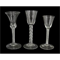 Three 18th century drinking glasses, the first example with bell shaped bowl upon a single series air twist stem, the other two examples with funnel bowls, one upon a single series air twist stem, the other upon a double series air twist stem, each upon conical feet, tallest H18.5cm