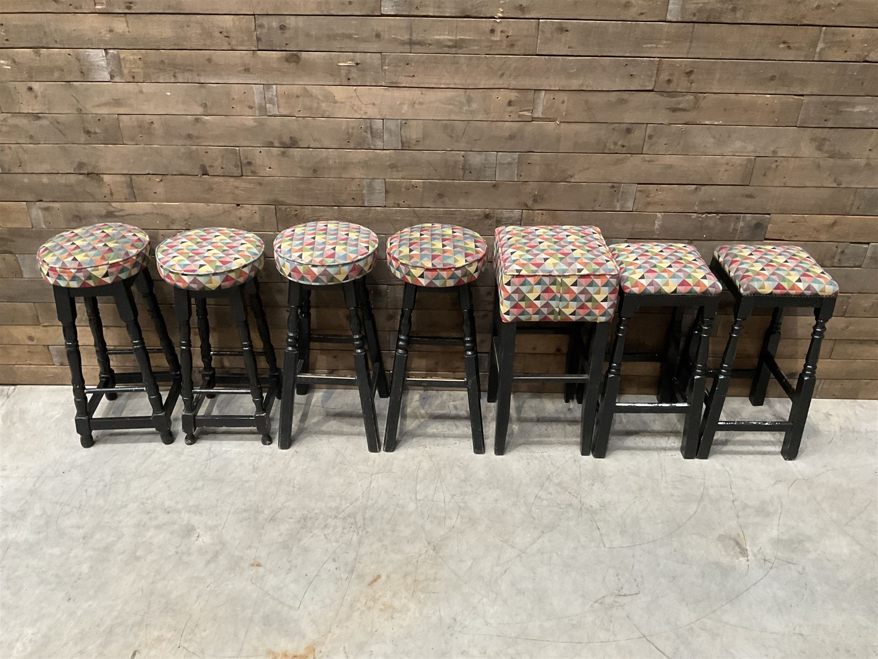 Seven tall bar stools with upholstered seat