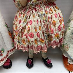 Anna Meszaros Hungary - three hand made needlewrok figurines - each wearing a lon floral dress and bonnet and holding a bouquet of flowers, tallest H32cm (3)  Auctioneer's Note: Anna Meszaros came to England from her native Hungary in 1959 to marry an English businessman she met while demonstrating her art at the 1958 Brussels Exhibition. Shortly before she left for England she was awarded the title of Folk Artist Master by the Hungarian Government. Anna was a gifted painter of mainly portraits and sculptress before starting to make her figurines which are completely hand made and unique, each with a character and expression of its own. The hands, feet and face are sculptured by layering the material and pulling the features into place with needle and thread. She died in Hull in 1998.