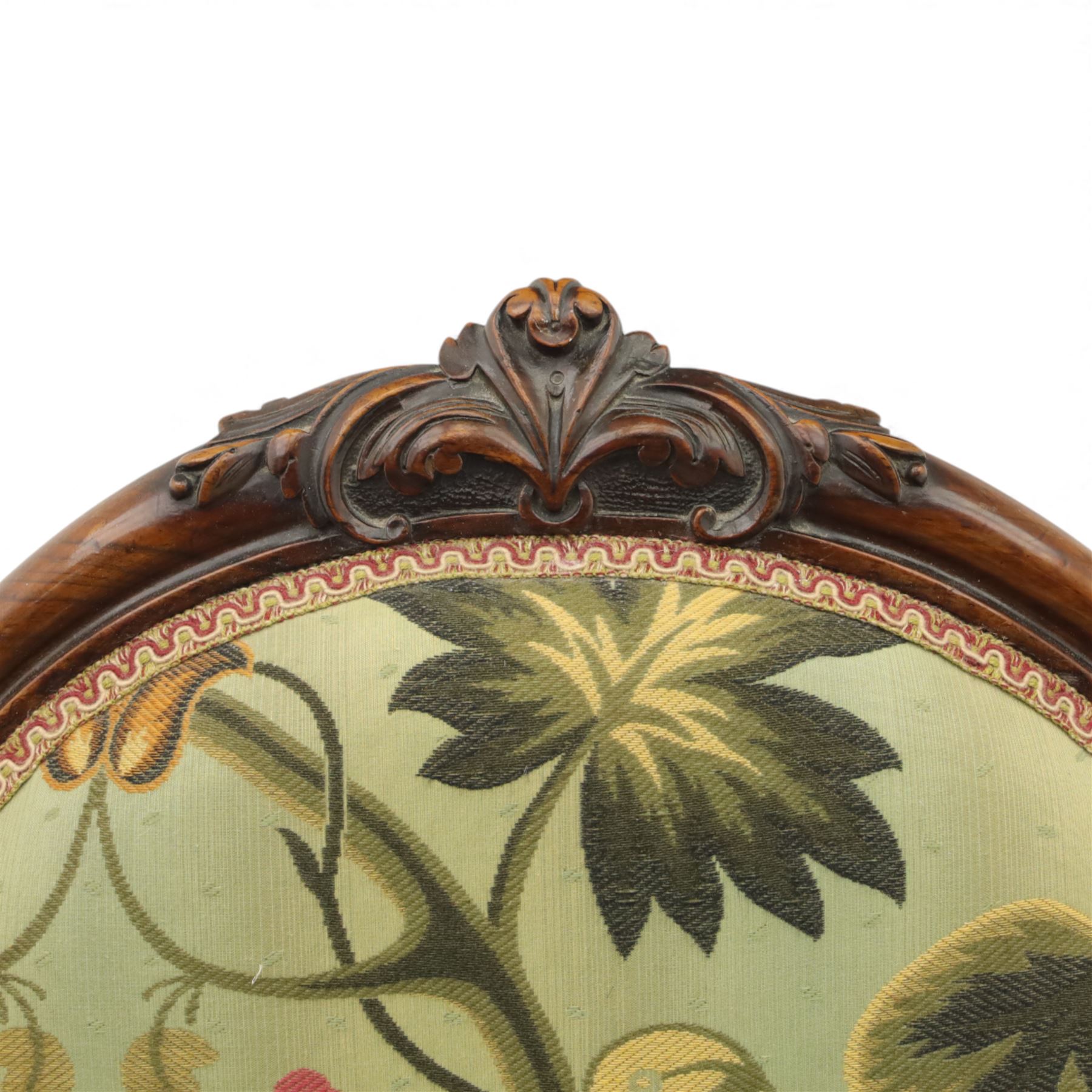 Small Victorian mahogany nursing chair, with carved top rail above a padded balloon back and shaped seat upholstered in light green fabric detailed with exotic birds and flowering vines, raised upon cabriole front legs and turned rear supports