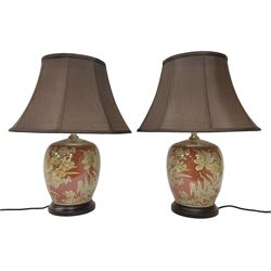 Pair of lamps of baluster form, decorated with daffodils upon a red ground, raised upon circular base, including shades H52cm