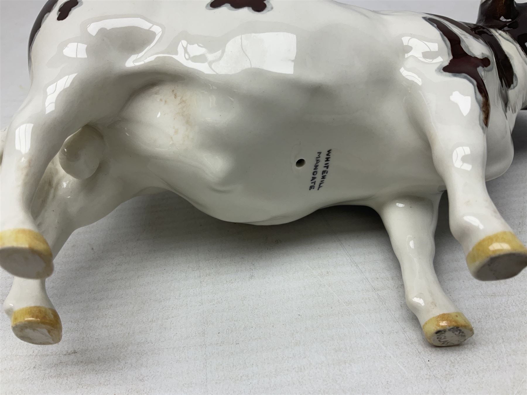 Five Beswick figures of cattle Comprising Ayrshire Bull Ch Whitehill Mandate, no 1454B, three Ayrshire Cow Ch Ickham Bessie, no 1350 and Ayrshire Calf, no 1249B, all with printed marks beneath