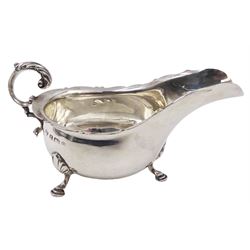 Early 20th century silver sauce boat, of typical form with shaped rim and acanthus capped flying C scroll handle, upon three palmette mounted hoof feet, hallmarked Thomas Edward Atkins, Birmingham 1915, including handle H8.5cm