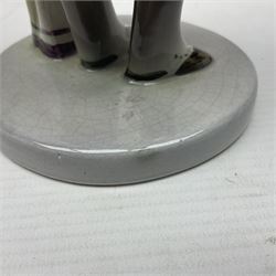 Goldscheider figure, modeled as a gentleman with flowers, upon a circular base, with printed mark beneath, H25cm