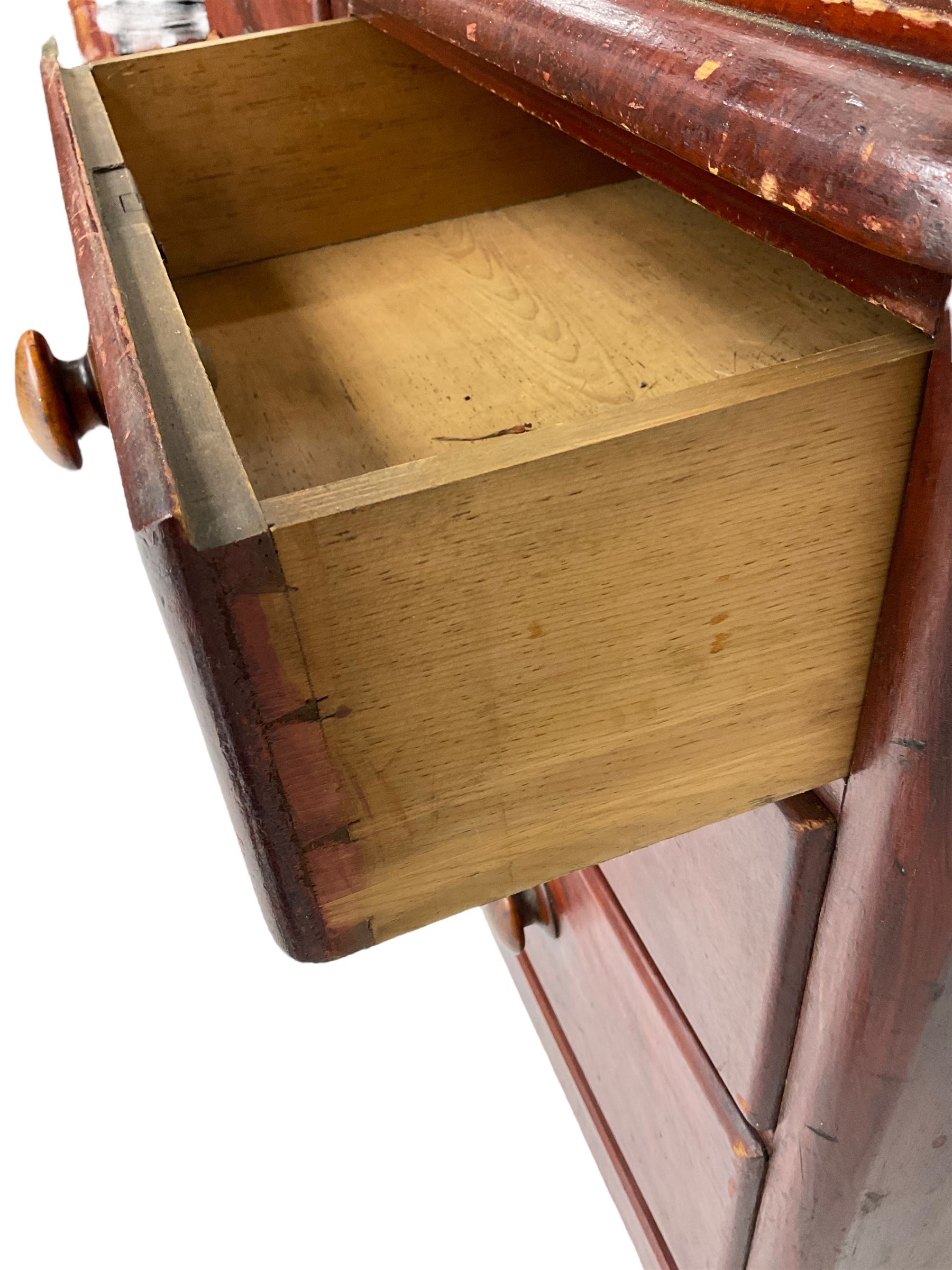 Victorian scumbled pine dressing chest, raised swing mirror in moulded frame with scrolled carved pediment, foliage S-scroll carved supports over trinket drawers, moulded rectangular top with rounded corners over two short and two long drawers, skirted base on turned feet, scumbled to resemble mahogany 