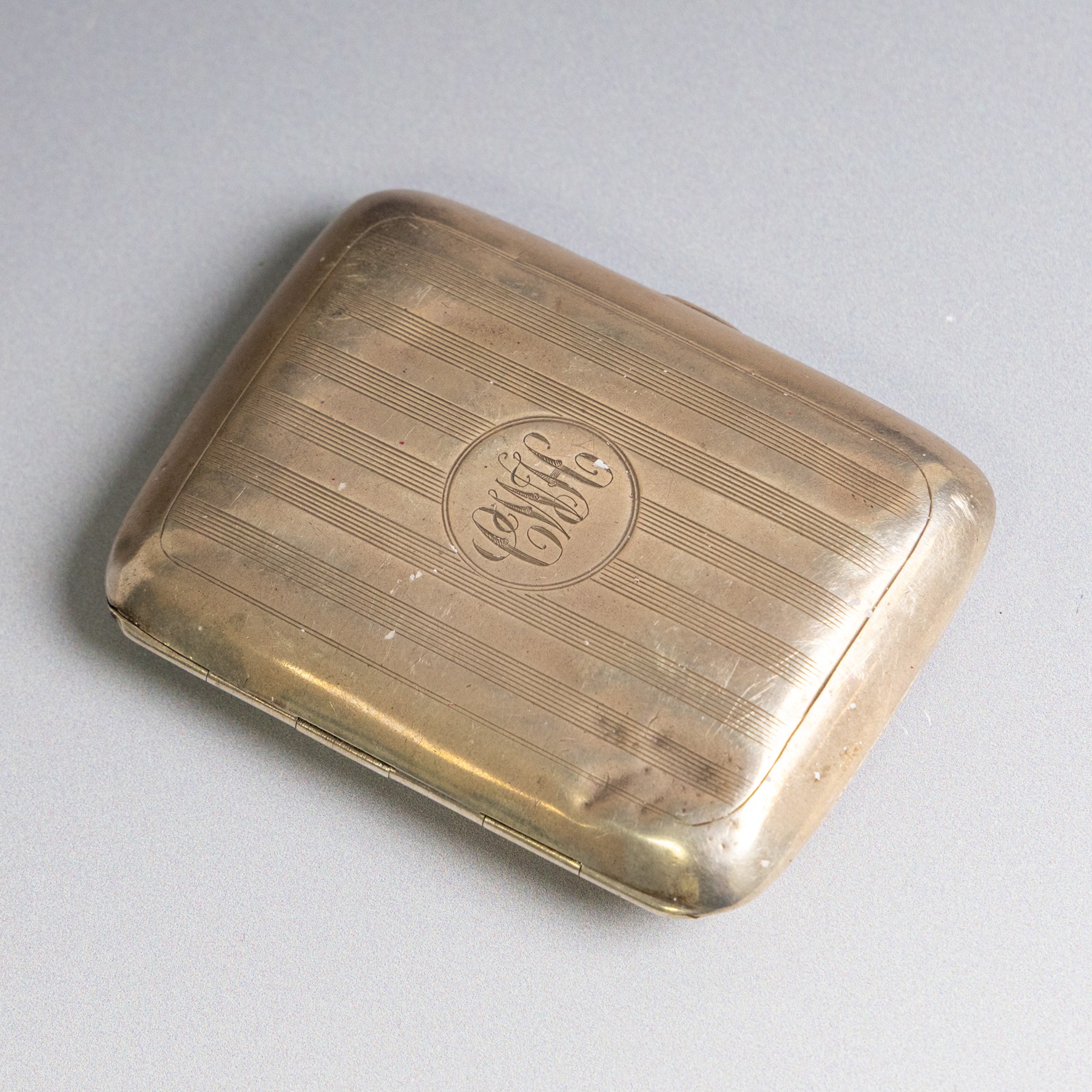 Early 20th century silver coin purse, with floral decoration and finger chain, hallmarked together with an early 20th century cigarette case,  with engraved initials, hallmarked and a silver filigree cigarette case