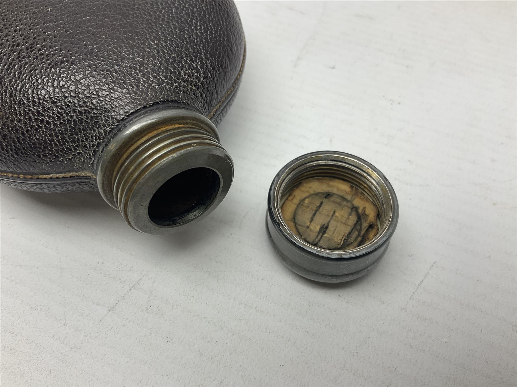 Silver plated glass and pressed leather hip flask, with swivel cap and removable cup, together with a similar oval example, engraved with wreath and initial B, tallest H16.5cm
