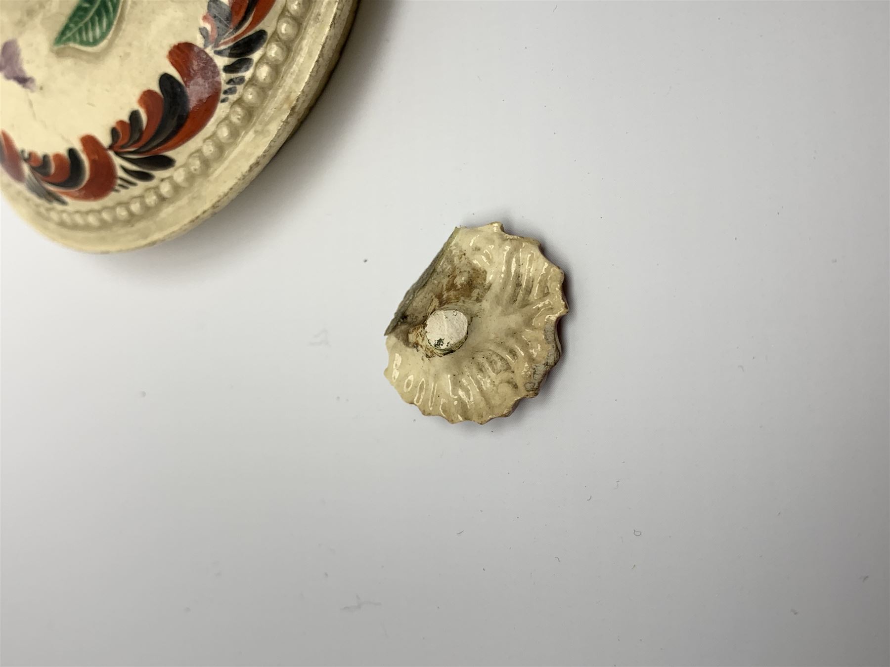 18th century creamware teapot, probably Leeds, with reeded entwined handle and floral finial to the cover, the body with hand painted polychrome decoration of figure to one side, and floral spray to the other, collectors paper label beneath inscribed Leeds Pottery, H11.5cm