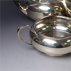 Mid 20th century silver four piece tea service, comprising teapot, hot water pot, open sucrier and milk jug, all of squat bellied form, the teapot and hot water pot with ebonised handles and finials, hallmarked Walker & Hall, Sheffield 1953, hot water pot H19cm