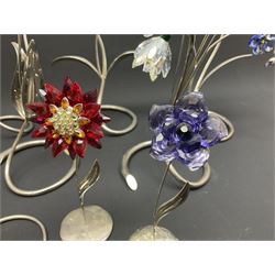 Eleven Swarovski Crystal flowers, to include violet, sunflower, delphinium, forget-me-not and lily-of-the-valley, each on stylised metal stems, tallest H23cm