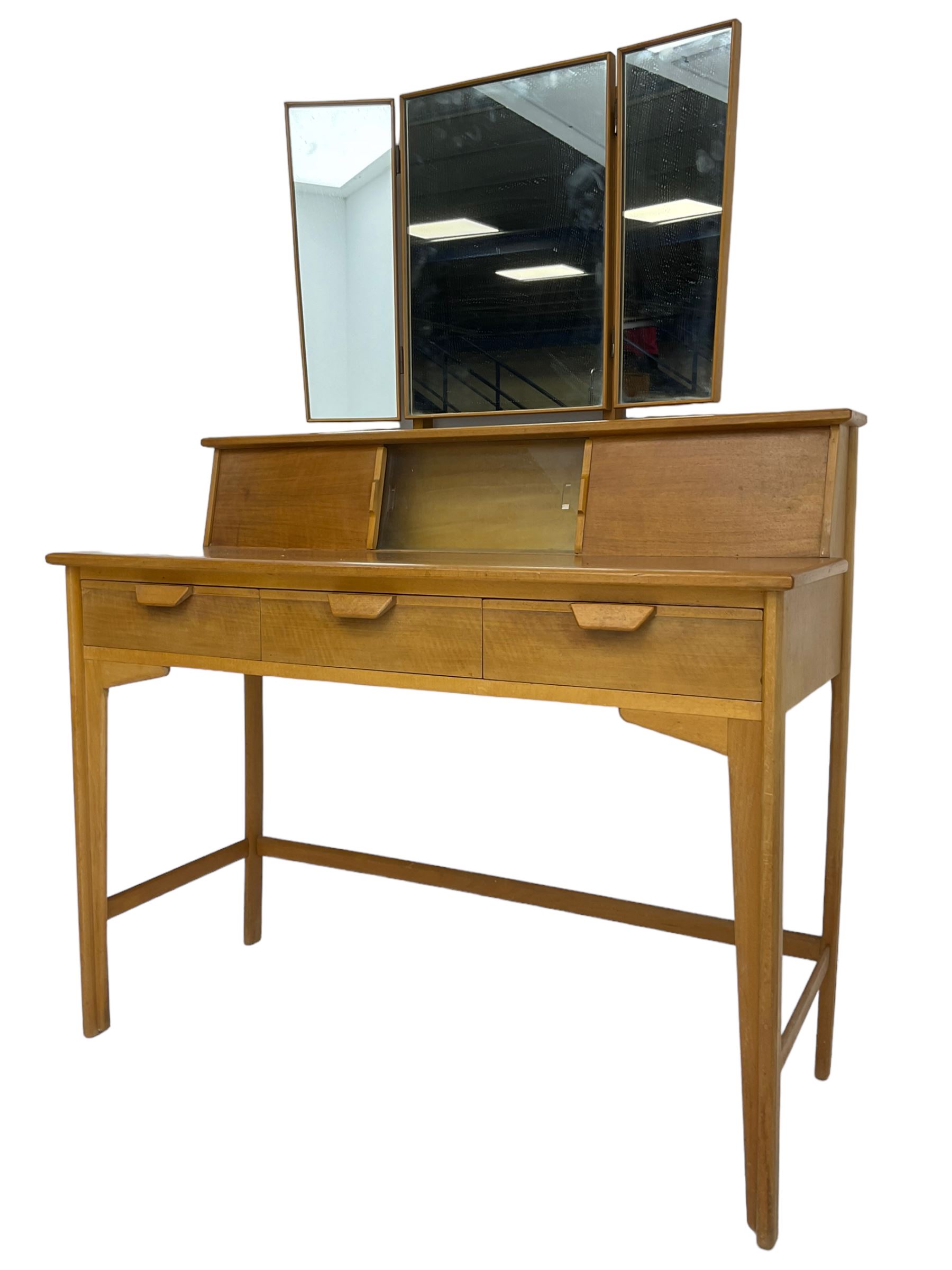 Heals of London - 1950s walnut and beech dressing table, raised triple mirror back over trinket compartments enclosed by sliding doors, above three drawers, on tapering supports