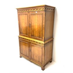 Mid century yew wood cocktail cabinet, projecting cornice, two doors enclosing mirrored interior with single shelf and slide above two cupboards, shaped platform base 
