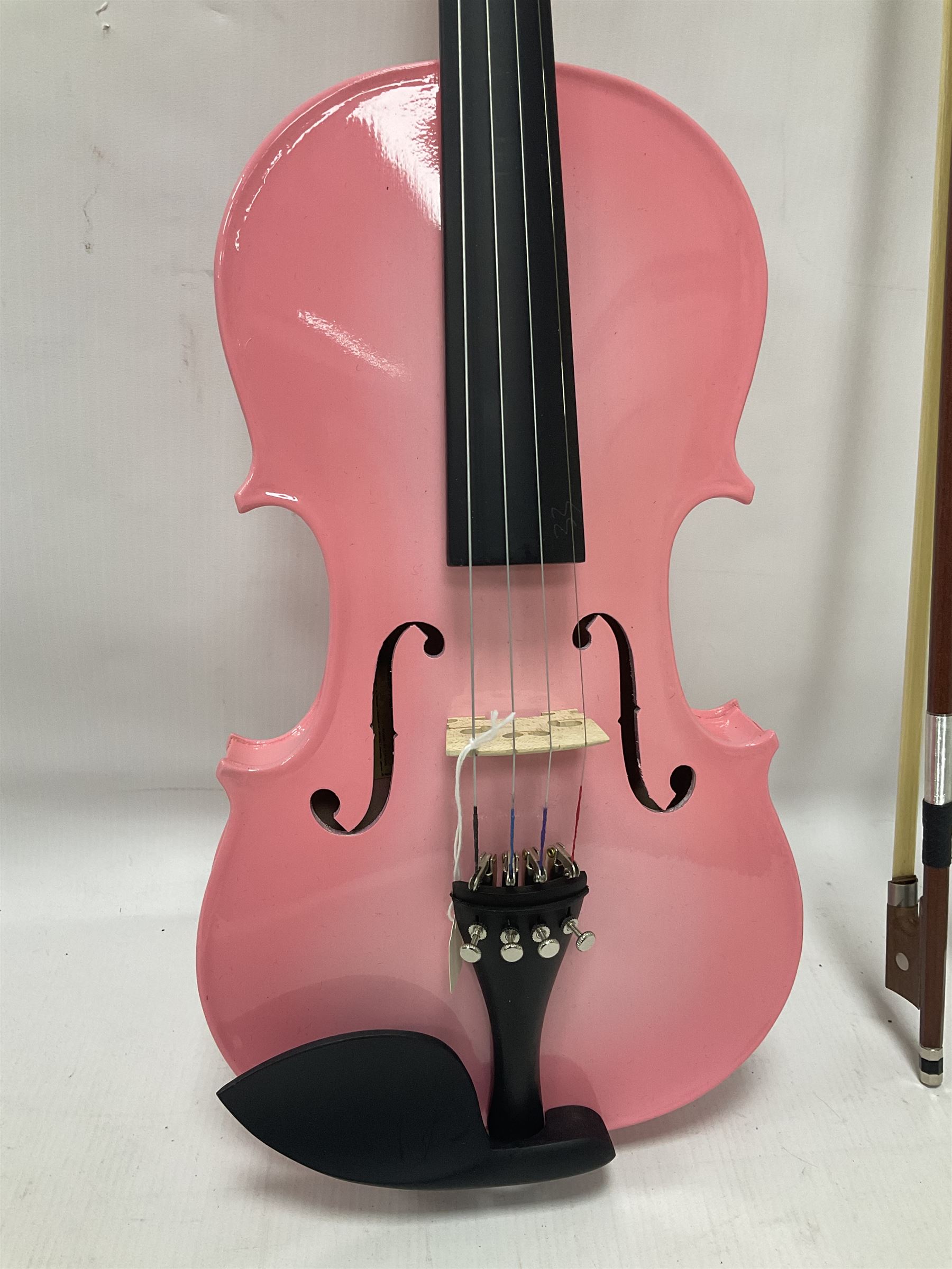 Zest full size pink violin, with a solid wood body and maple head, with matching pink bow and two further bows, in a hard case Length 60cm