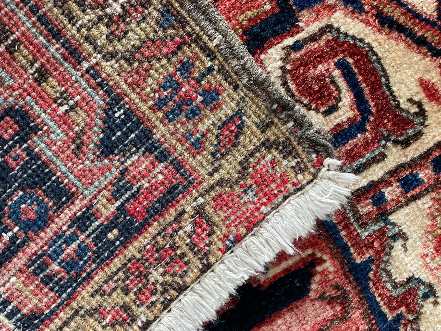 Persian Heriz red ground rug, large medallion decorated with palmettes and Ejder motifs, the border decorated with stylised plant motifs, within floral design guard stripes 