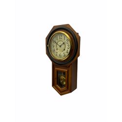 Contemporary spring driven wall clock striking the hours on a gong, case with a wooden octagonal dial surround and two piece creme dial with Arabic numerals, steel spade hands, brass effect pendulum bob visible through case door, dial inscribed 