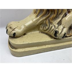 19th century salt-glazed stoneware door porter, as a recumbent lion, upon a stepped plinth base, H32