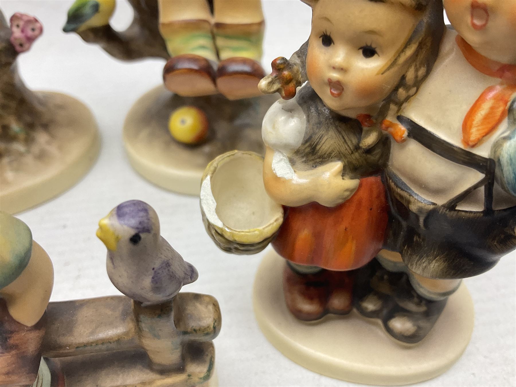 Seven Goebel Hummel figures, comprising Chimney Sweep 12/I, Apple Tree Girl 14/I, Apple Tree Boy,  Little Goat Herder 200/I, Surprise 94 3/0, Signs of Spring 203/20 and Wayside Harmony 111/30, tallest H15cm