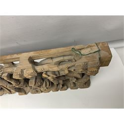 Two carved oriental wall hangings, the first example gilded depicting a temple and garden scene, the second figures in a garden, L49cm