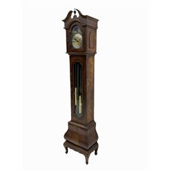A late 20th century “Grandmother” clock in a figured mahogany veneered case with a break-arch hood and turned central finial,  shaped full length glazed door with visible pendulum and triple brass cased weights, bombe base raised on bracket feet, brass dial with an etched centre, brass spandrels and silvered chapter ring with Roman numerals, working moon dial and pierced steel hands, three train weight driven European movement chiming the quarters on 8 gong rods. With strike /silent feature.

