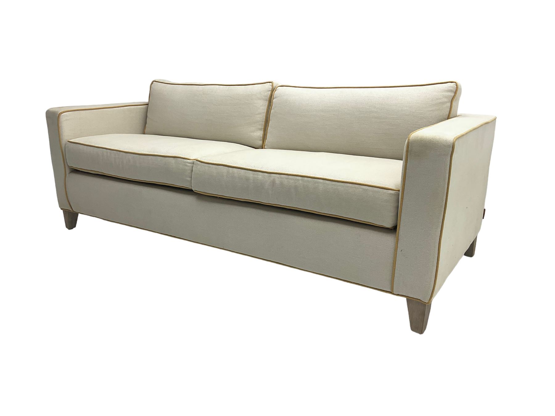 Neptune - pair three seat 'Shoreditch' sofas,  upholstered in cream fabric with yellow stringing