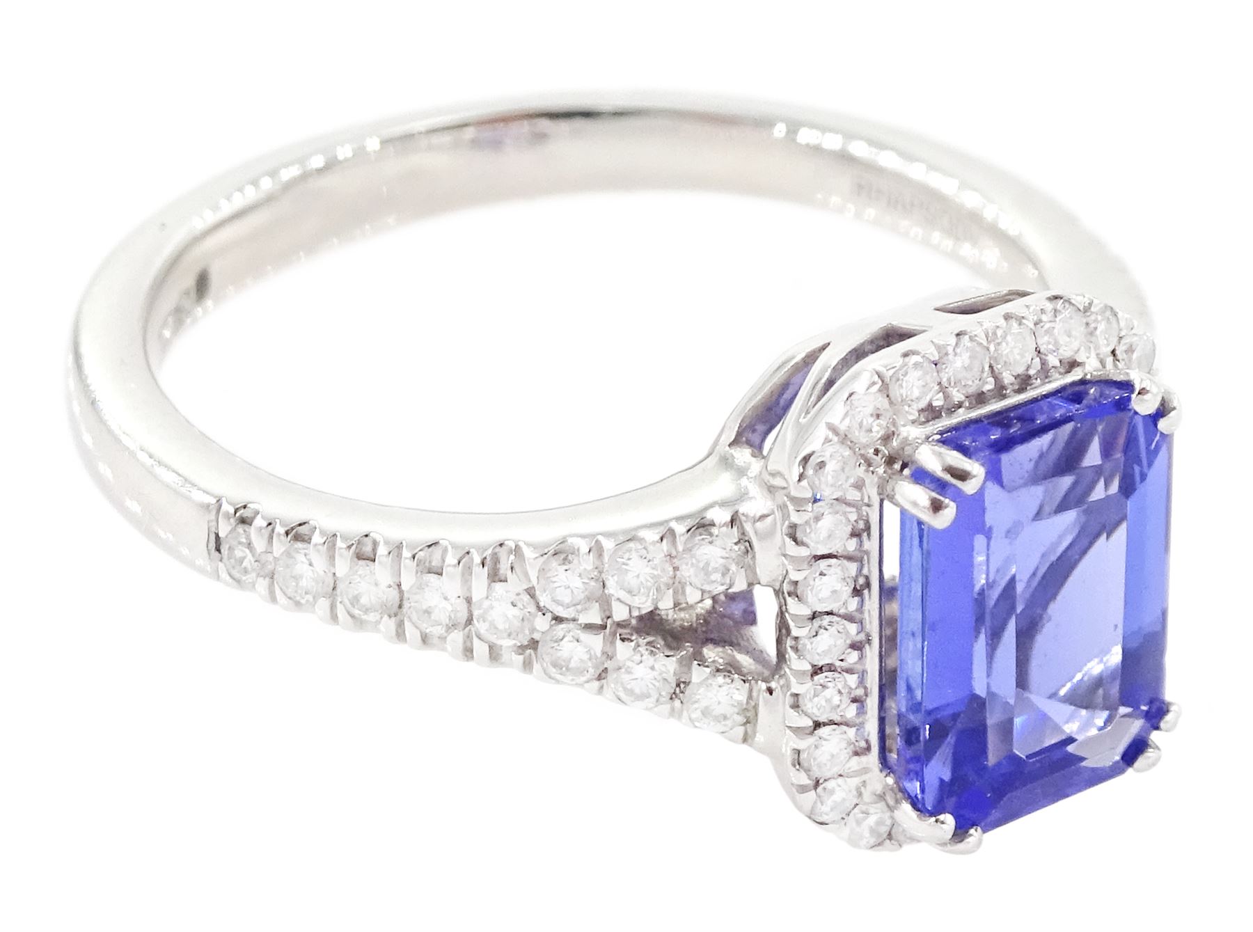 Platinum tanzanite and diamond cluster ring, single emerald cut tanzanite of approx 1.75 carat, with round brilliant cut diamond surround and split diamond set shoulders, signed Rhapsody, hallmarked, total diamond weight approx 0.20 carat