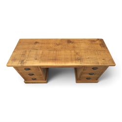 Indigo Furniture - rustic oak twin pedestal desk, rectangular plank top, with central frieze drawer, the fixed pedestals with three drawers and metal cup handles, raised on a plinth base