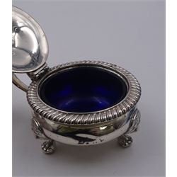 1930's silver mustard pot and cover, of squat bellied form with oblique gadrooned rim and capped scroll handle, the slightly domed cover lifting to reveal a blue glass liner, upon three lion mask mounted paw feet, hallmarked Ellis & Co, London 1935, H6.5cm, approximate weight excluding liner 5.33 ozt (166.1 grams)