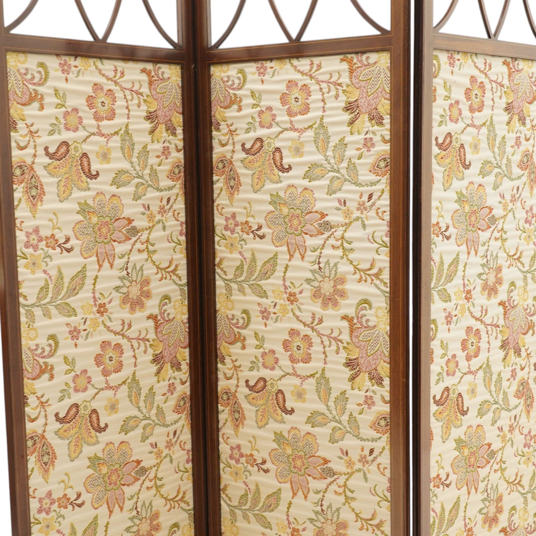 Edwardian inlaid mahogany three-fold screen, each panel with shaped cresting and satinwood line inlaid frame, with intersecting astragal bars, lower panels upholstered in floral fabric, hinged folding action on brass hinges