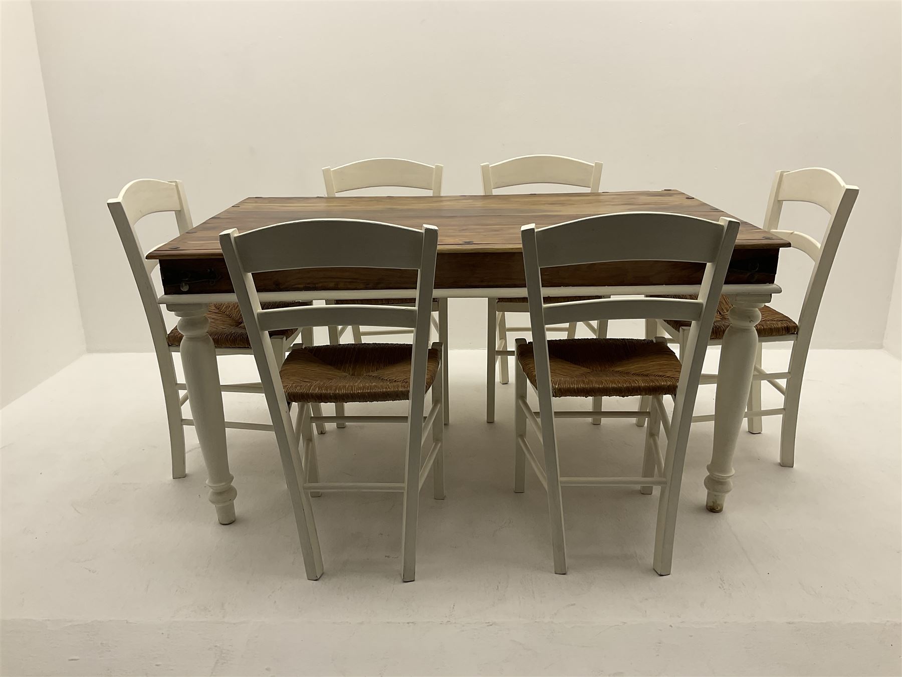Mexican painted and polished pine rectangular dining table, raised on turned supports (W150cm, D90cm, H76cm), together with six chairs, rush seat raised on square supports (W40cm)