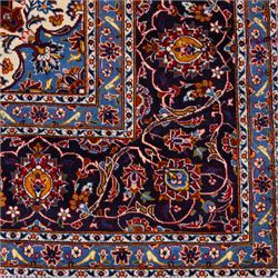 Central Persian Kashan hand-knotted carpet, rich crimson red field with a central cusped medallion with finely drawn floral sprays surrounded by dense scrolling vine work and palmettes, framed by a broad indigo ground border of flowering arabesques flanked by multiple guard stripes, in a palette of red, blue, ivory, sage green, and soft ochre tones, with cotton fringe ends    