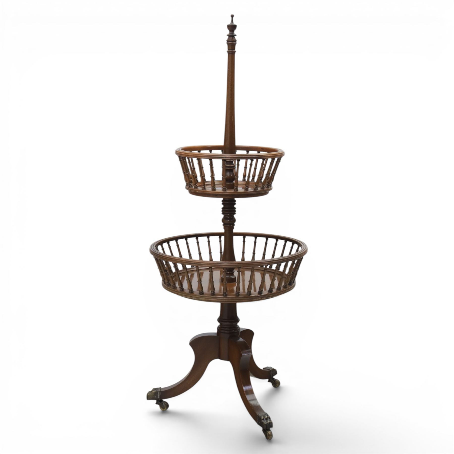 Regency style oak two-tier dumb waiter, with turned finial above central column support, two circular spindle-galleried basket tiers, raised on downswept tripod supports with brass caps and castors