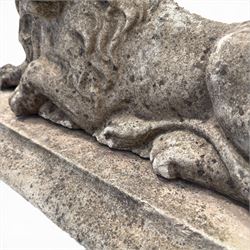 Neoclassical design cast stone garden lion, modelled recumbent with raised and flowing mane, on rectangular plinth base, with flat plain reverse, in weathered finish