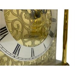 A 20th century brass cased Kieninger (German) chiming mantle clock with a break arch top and three glazed panels, polished sheet brass dial with applied  brass fretwork and a silvered chapter ring, Roman numerals, minute track, steel serpentine hands and seconds dial, three-train spring driven 8-day movement with Westminster, St Michael and Whittington chimes on 8 gong rods, 9 jewel lever platform escapement.  With key. 
