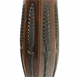 Hepplewhite design mahogany standard lamp, faceted bulbous column decorated with stylised leaf carvings, on three splayed supports 