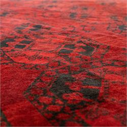 Turkmen Bokhara carpet, with a deep red field and repeating rows of black gul motifs, within multiple geometric borders