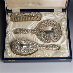 Silver mounted three piece dressing table set, comprising hand mirror, hairbrush and clothes brush, all with embossed green man and floral decoration, stamped Filled and hallmarked Broadway & Co, Birmingham 2001, contained within presentation box